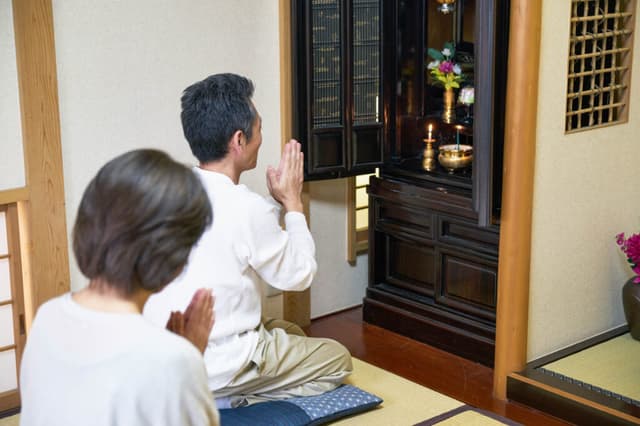 仏壇の前で手を合わせるご夫婦